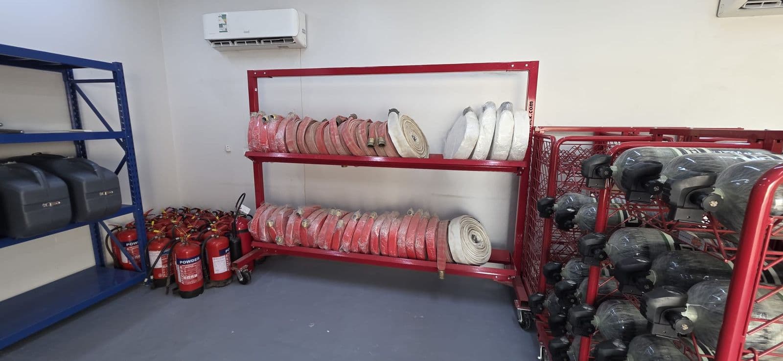 Rolled hose and breathing apparatus stored on racking in the equipment store.