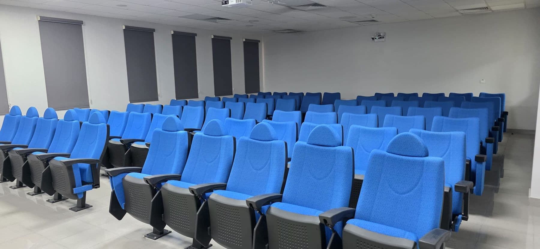 Rows of fixed seating in the lecture hall, each position with its own writing tablet.