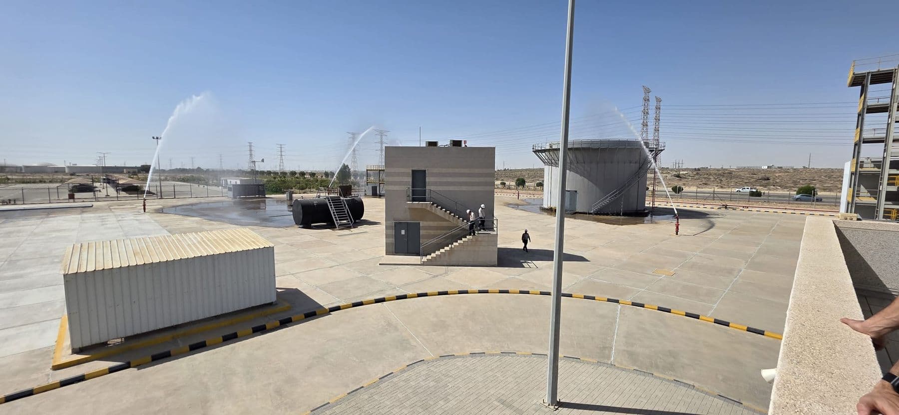 Container and vessel props set out across the fire ground with water running from one of them.