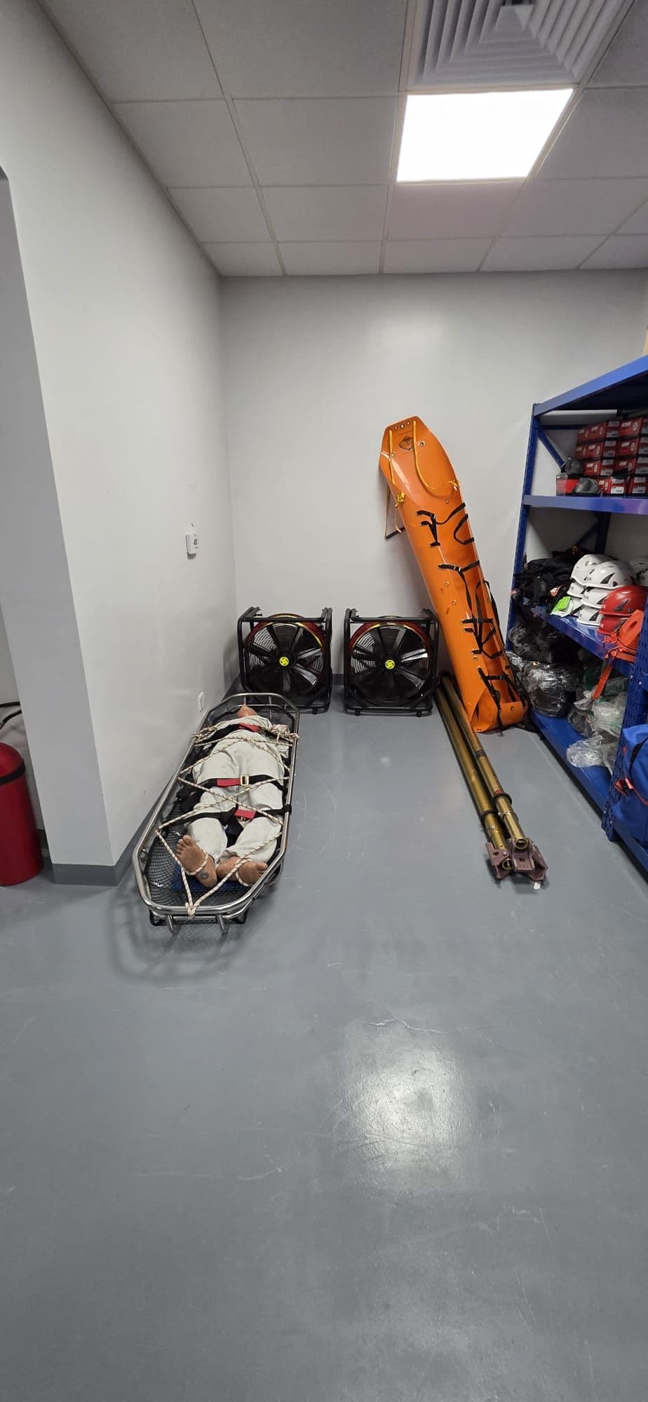 Rescue stretchers and hydraulic rescue equipment stored on shelving.